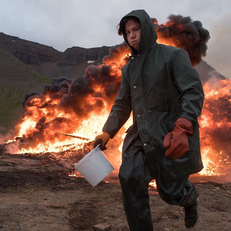 A local feeds a bonfire with diesel fuel in northern Iceland.