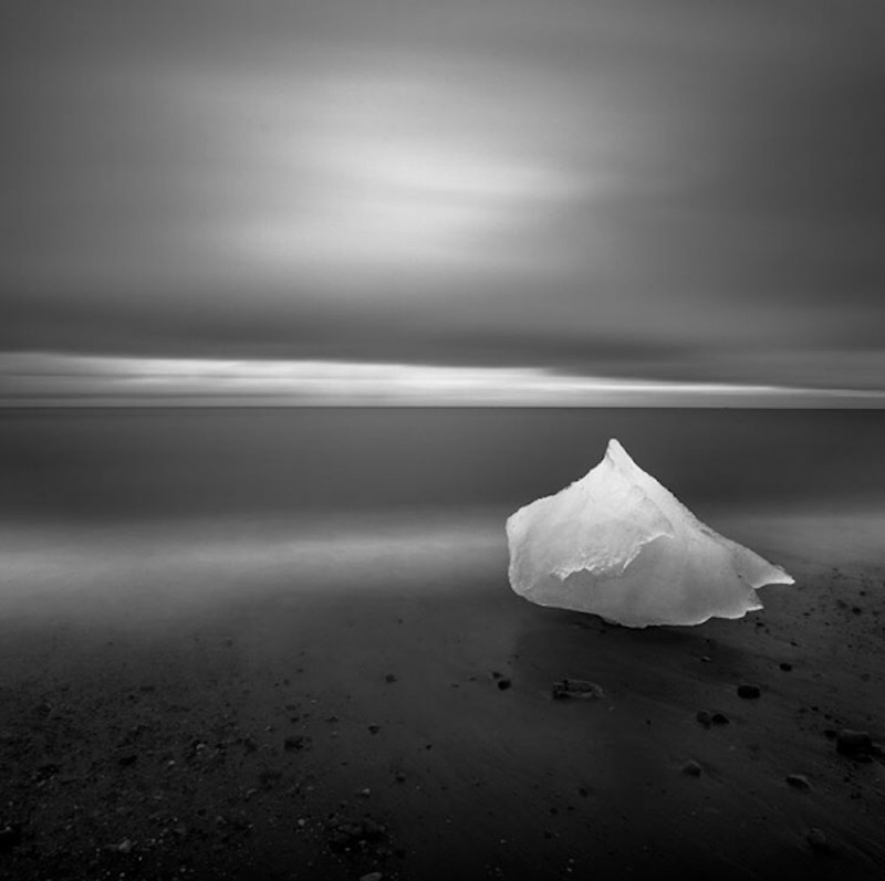 A piece of ice sits on the beach.