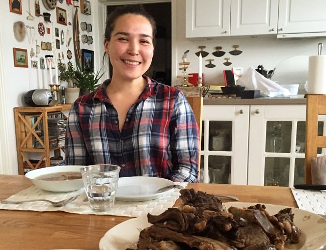 Tuku with the caribou soup prepared from a successful hunt with her father.