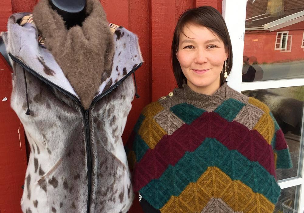 Davidsen in a handmade muskox wool shawl next to one of her sealskin vests.